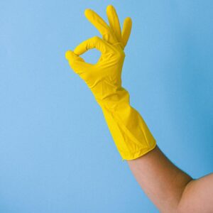 Crop faceless person in rubber glove showing okay gesture