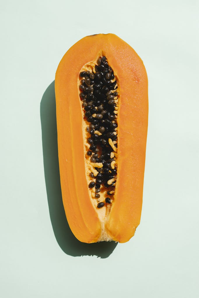 Half of papaya on light background